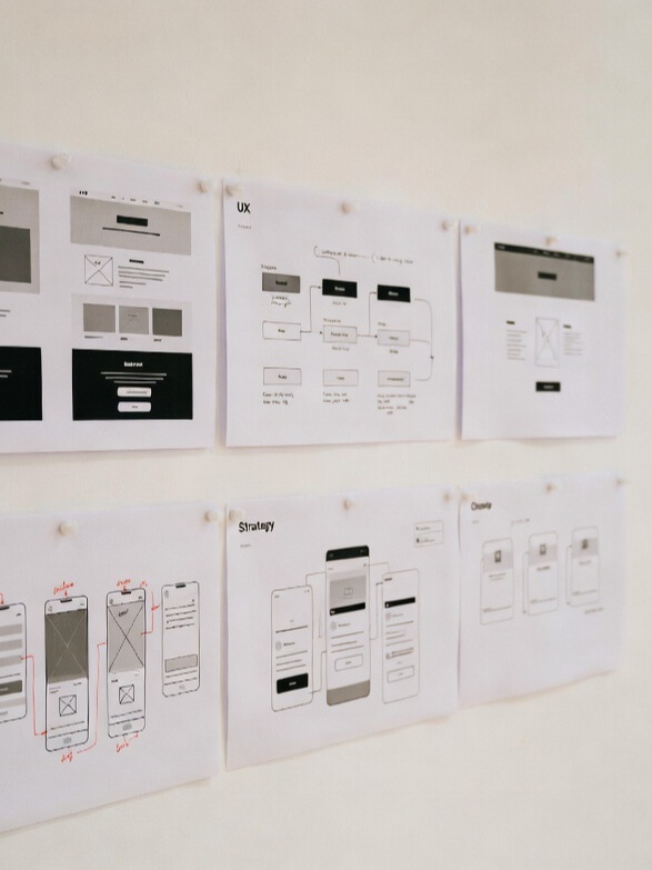 UX wireframes and website layout planning displayed on a wall during the website design strategy phase